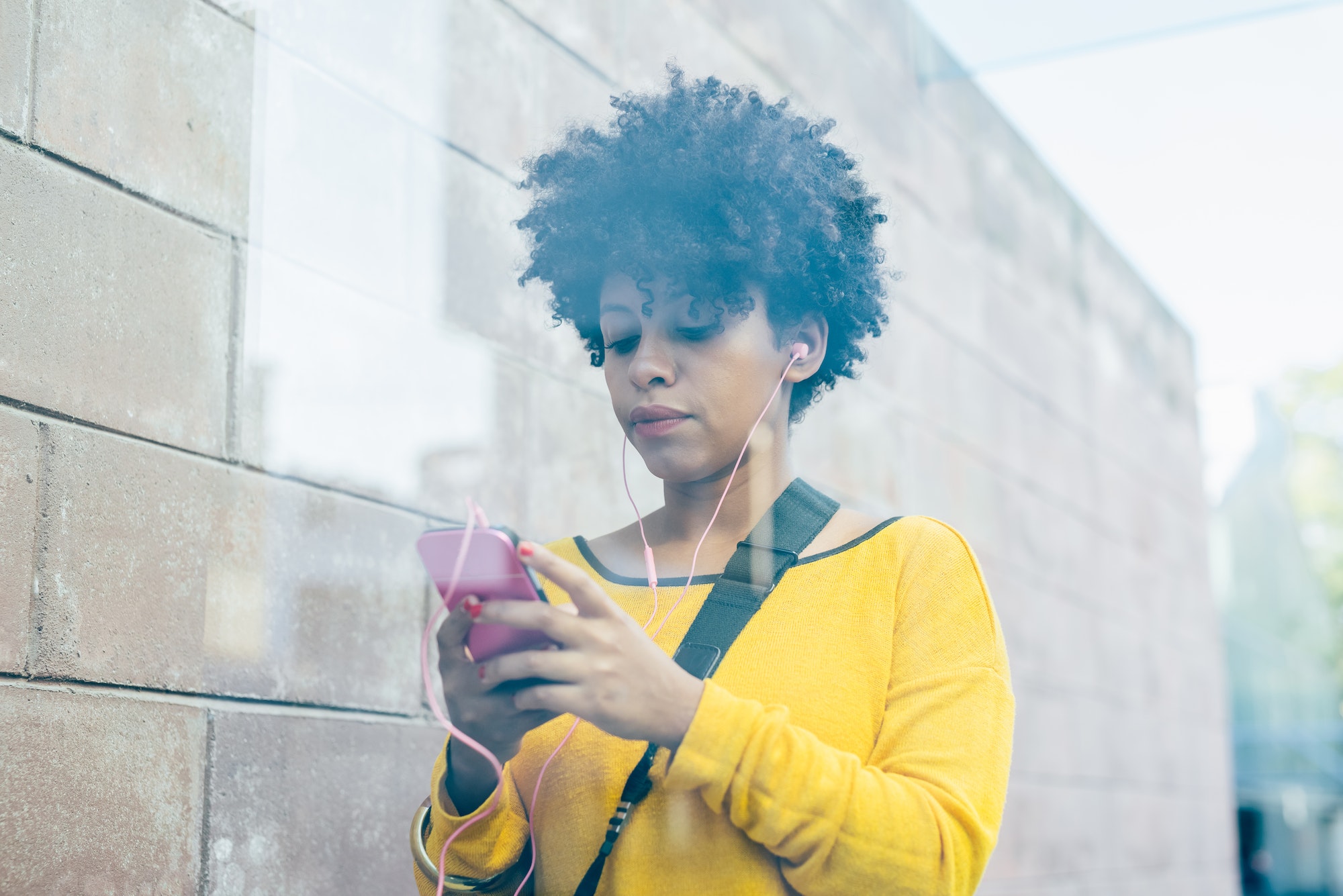 Black woman using smartphone listening music