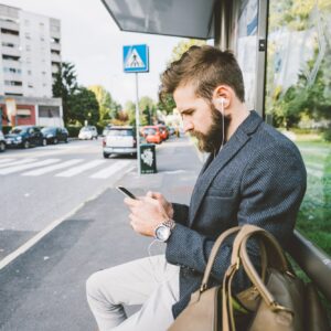 Young bearded man using smartphone listening music