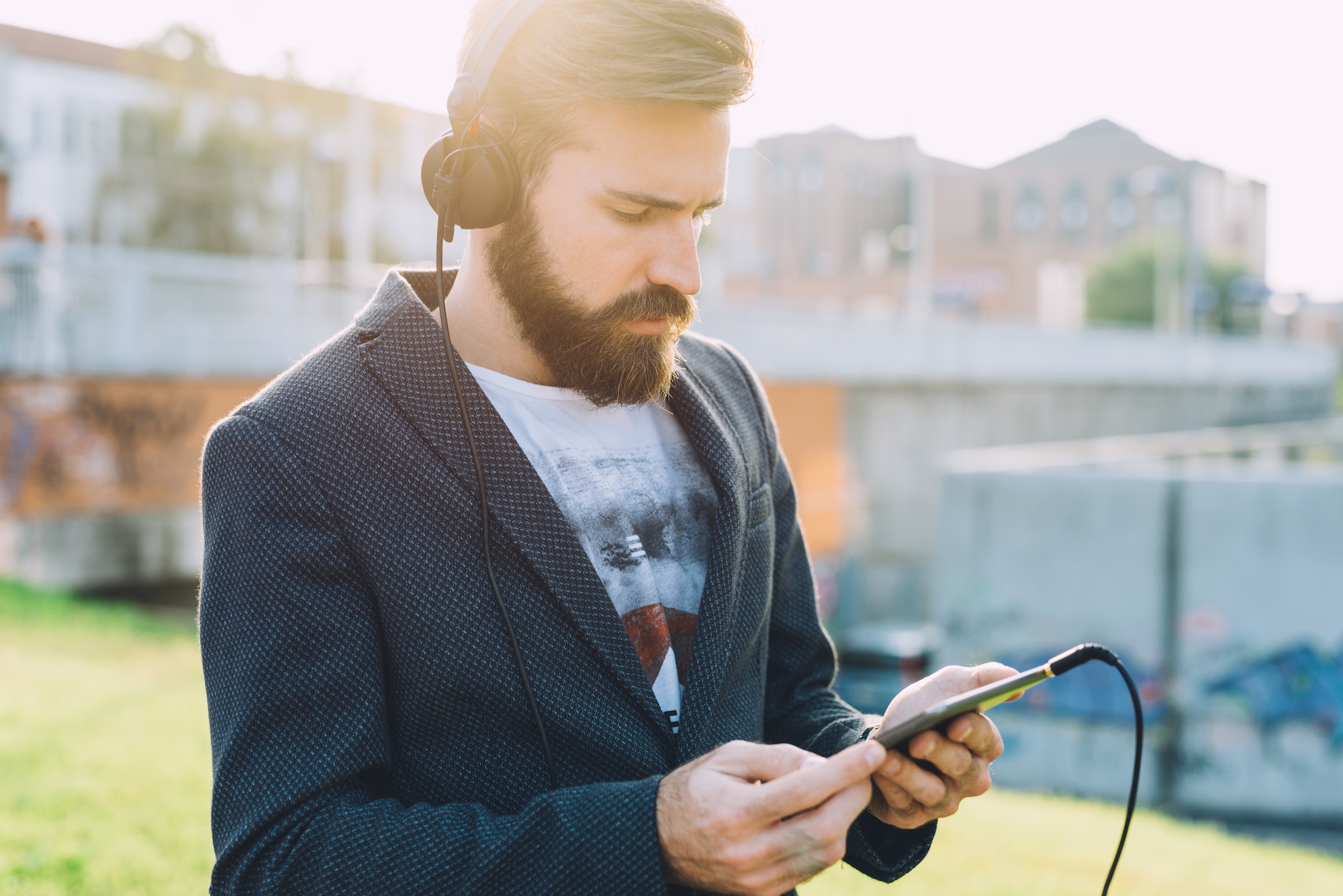 Young bearded man using tablet listening music