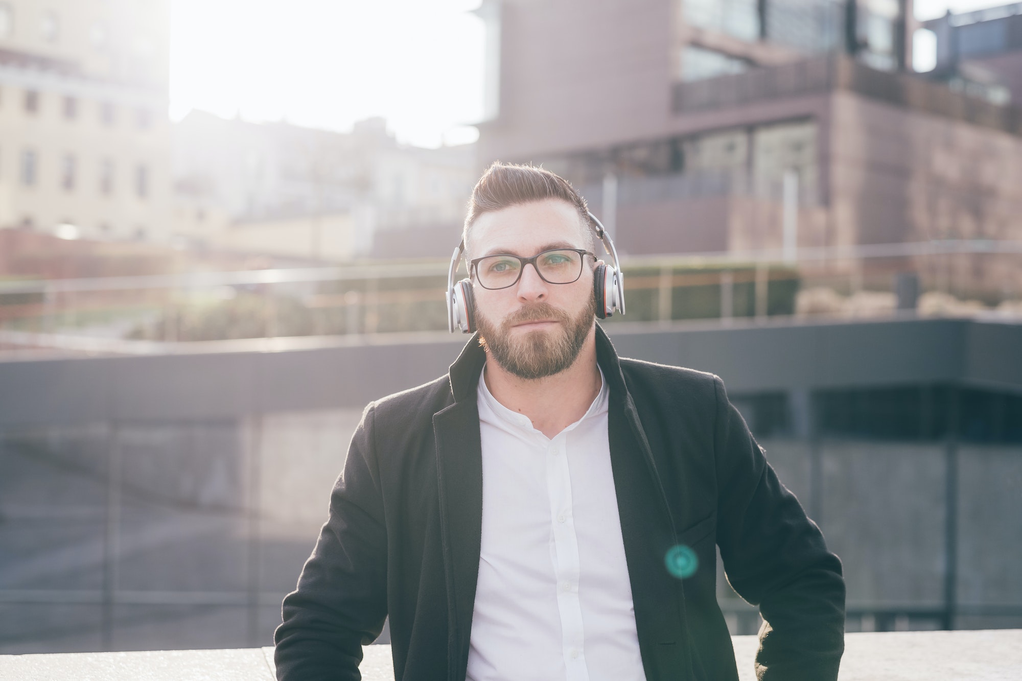 Young caucasian bearded man outdoor listening music